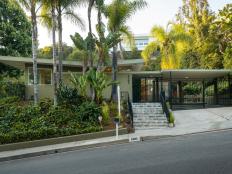 This midcentury modern ranch home has palm trees out front.