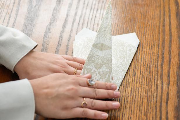 The next step in creating this Thanksgiving turkey paper napkin fold is to fold the tip back.