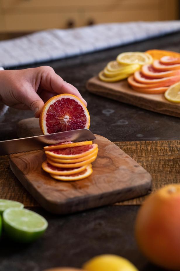 The first step in drying citrus fruits for holiday decorating is to slice the citrus into even slices.