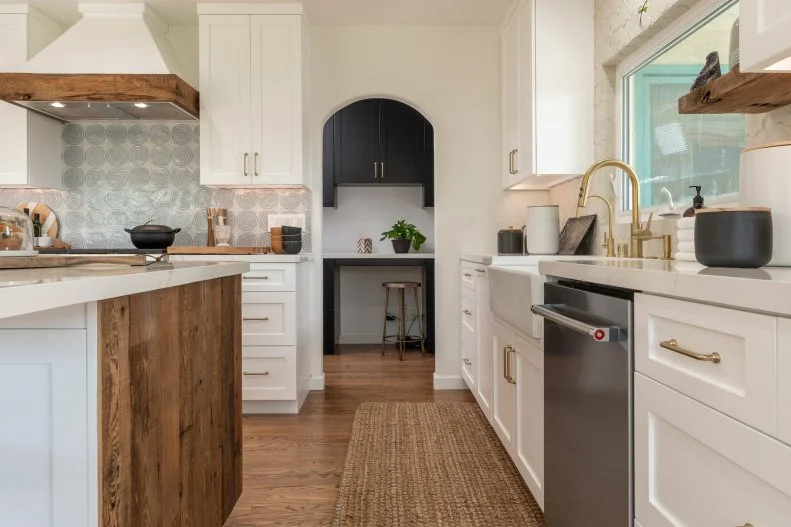 The Freese’s kitchen after renovations, featuring a new floor plan with a large island, new cabinets, windows, appliances, and unique details, and an alcove door leading to an office space, as seen on Christina on the Coast.