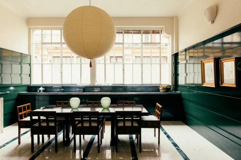 Cream room with green lower half and large paper globe with table.