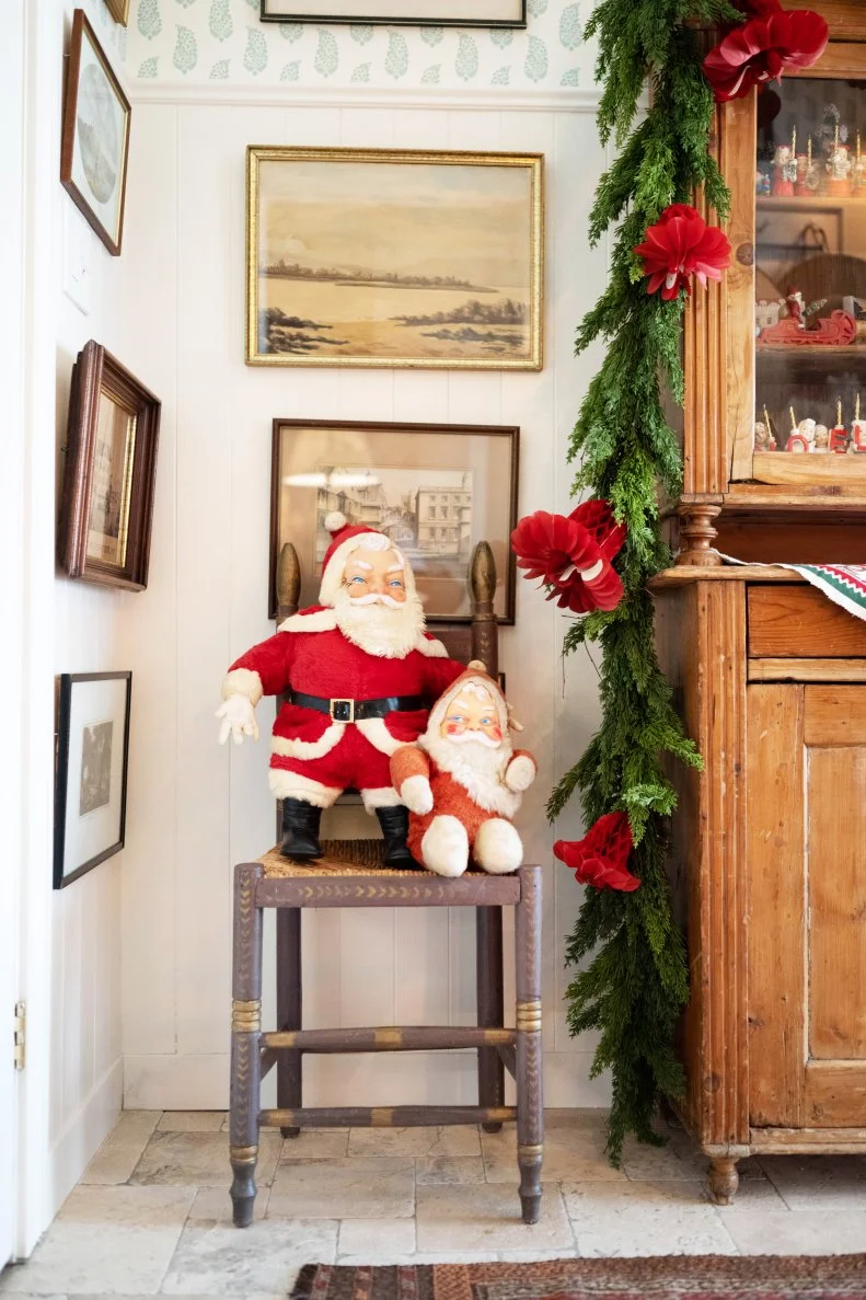 Two vintage Santas take up the seat in the corner of the kitchen
