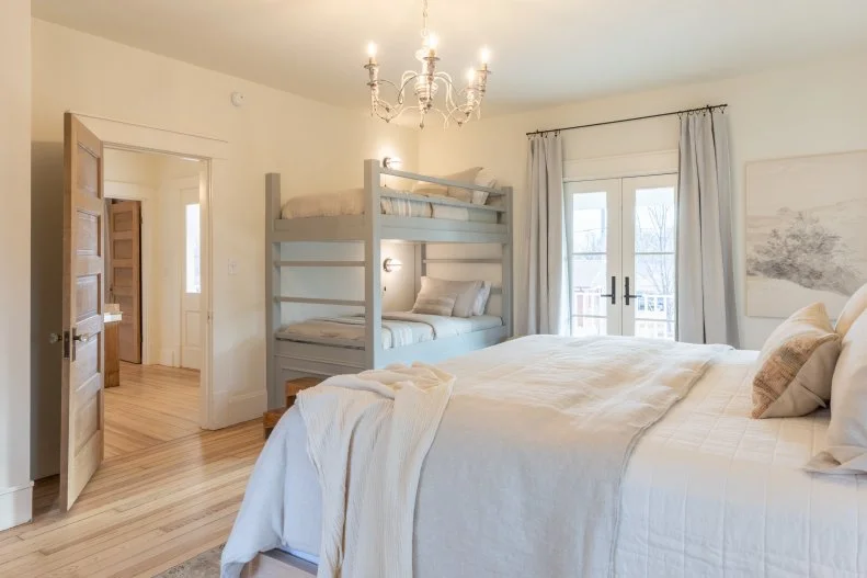 As seen on Fixer to Fabulous Welcome Inn with hosts Dave and Jenny Marrs, the main bedroom on the second floor of the renovated home. It features a bunk bed for families staying in the home.