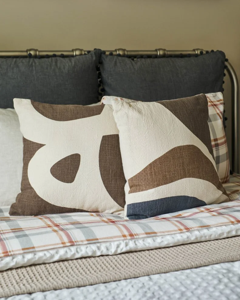 Abstract, graphic patterns are found throughout the space from the artwork to the throw pillows for a bold yet soothing accent.