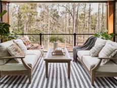The upstairs porch at HGTV Smart Home 2022 opens to lush backyard views and provides ample seating to relax and unwind while covered from the elements