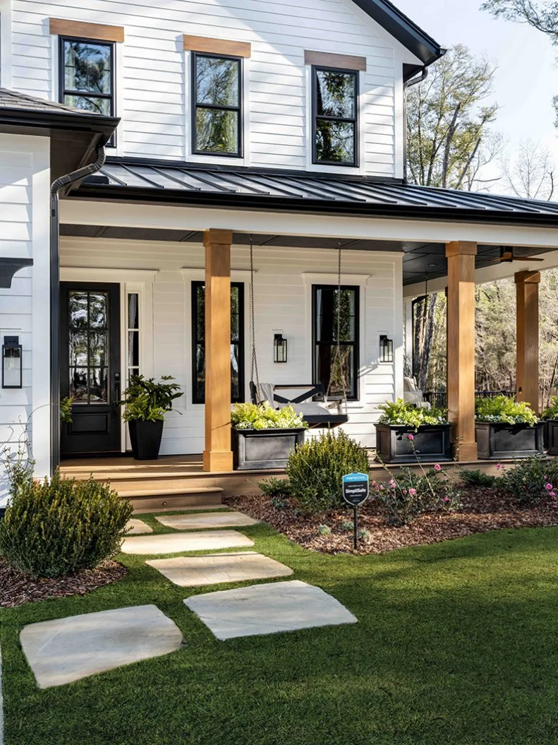 Rustic cedar wood accents offer warm contrast for the home’s classic black and white exterior, and reflects the woodland landscape that surrounds this spectacular Wilmington, North Carolina property. 