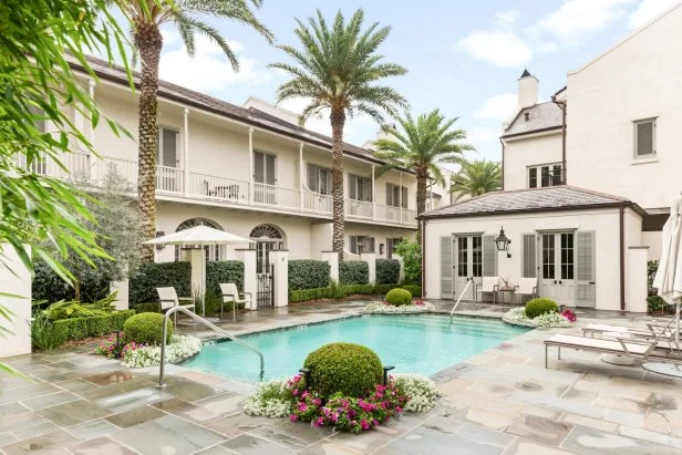 Flagstone patio surrounding pool with townhouse in background. 