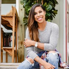 (left to right) As seen on HGTV's Battle on the Beach, mentor Taniya Navak poses for a photo in front of the beach house as a part of the exterior design challenge. Design highlights include a new beach shower and towel rack along with a lounge area underneath the home.