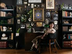 Talent Madelyn Vagott sits in front of the gallery wall in this Dark Academia-inspired bedroom makeover.