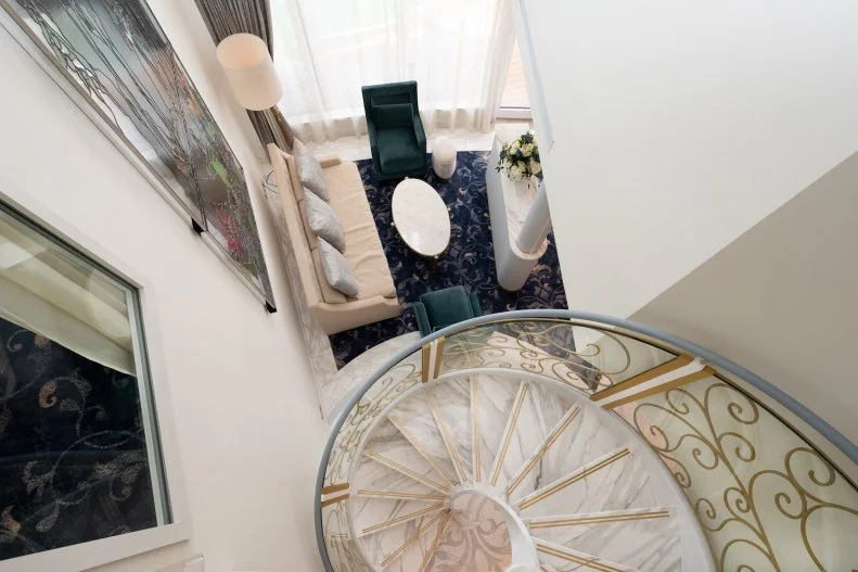 Looking Down at Living Room From Above Marble Spiral Staircase