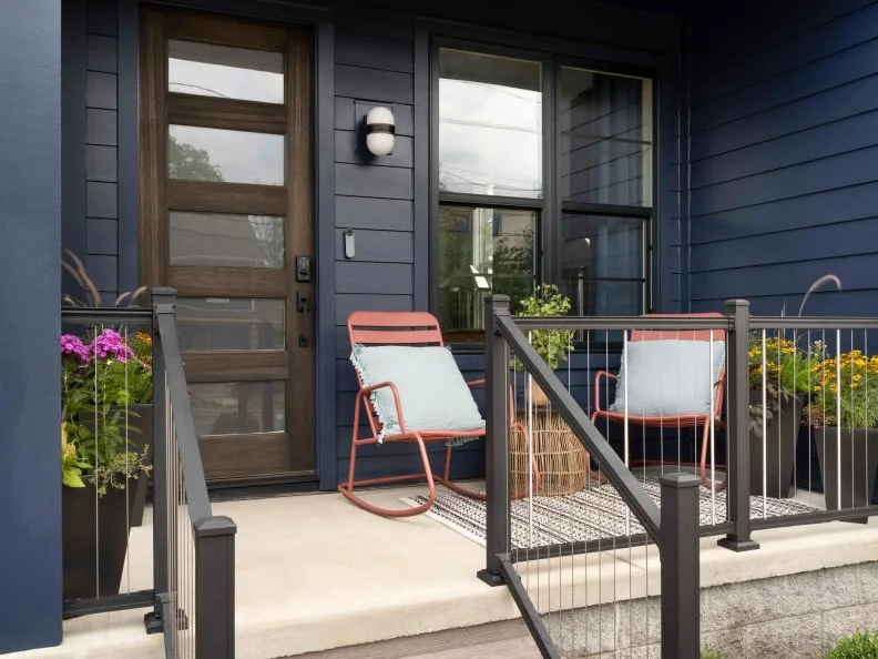 Pops of pink, purple and yellow on the front porch from the chairs and flowers add life and color to keep the eye moving and give the space an inviting feel.