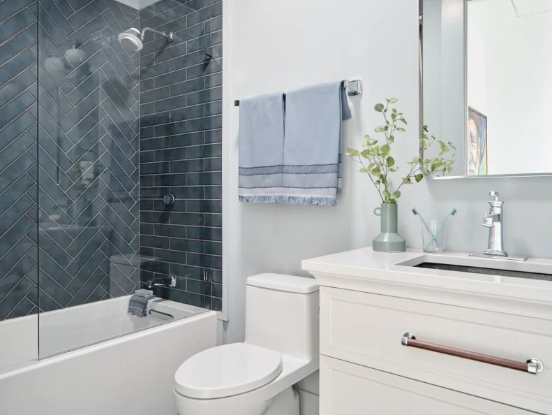 Light blue-silver walls, ceiling and trim provide a soothing backdrop for this contemporary guest bathroom, that sits just steps from the rust guest bedroom and the green guest bedroom on the home’s second floor.