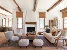 White room with exposed beams and fireplace.