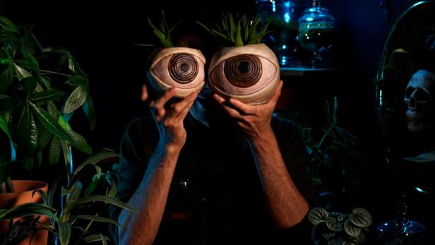 Man Holds Two Eyeball Clay Planters In Front of Face