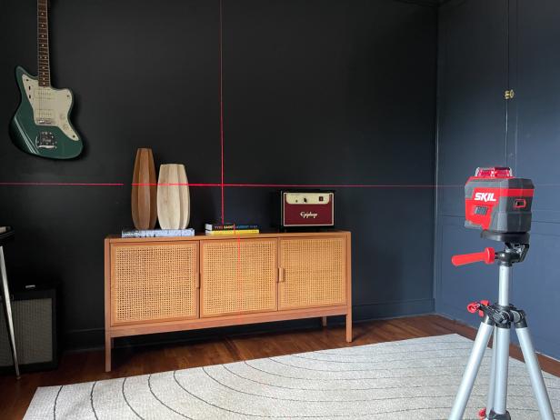 To hang a gallery wall using a laser level, set the laser level to project on the wall and align the beams with your desired layout.