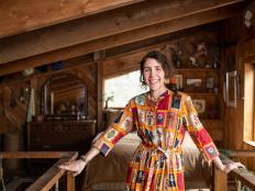 Woman Stands In Upstairs Loft of Wood Cabin in Maine
