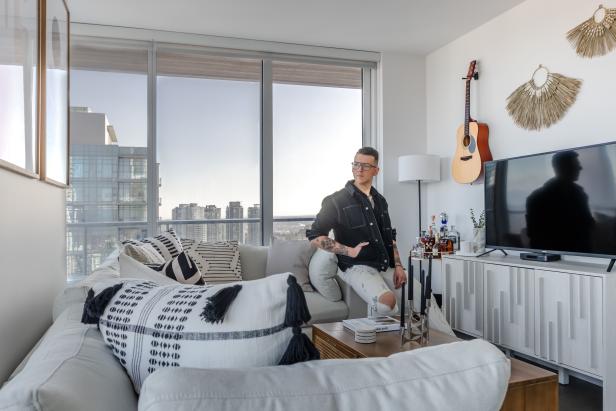 Man Standing By TV Console and L-Shaped Couch