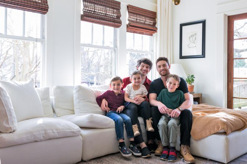 Two Men and Three Kids Pose for Photo on White Sofa in Living Room