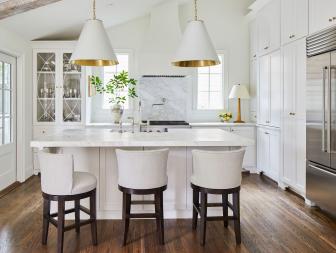 Large Pendant Lights Above Marble-Topped Island in White Transitional Kitchen
