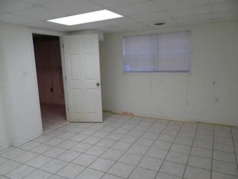 Prior to a renovation, this room was dark and had an unattractive drop ceiling and outdated tile flooring.