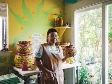 A photo of ceramic artist Gabo Martinez holding her pottery.