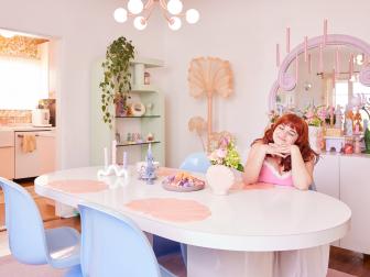 Woman in Eclectic Retro Dining Room With Pastel Accents 