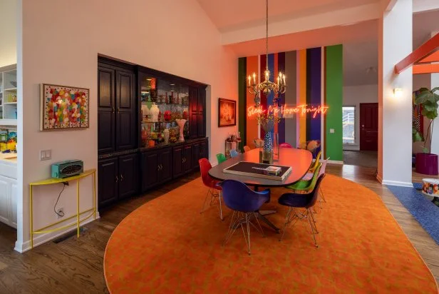 “The only pop of color with this built-in [when] we moved in was the countertops, so I actually played off the color and painted the wood to be a complementary hue,” designer Jenna Pilant explains. To the alcove’s left, she offset that deep tone with a bright abstract canvas by Atlanta artist (and HGTV Handmade home-tour alum) Cassie Birchette; on the floor, she echoed her new dining table’s lozenge shape and defined the room with a toasty orange area rug. Molded plastic Eames chairs round out the “Technicolor dining room.”