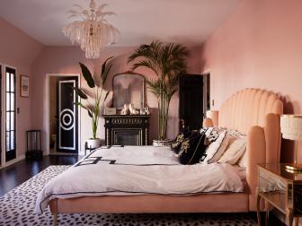 Pink Hollywood Regency Bedroom With Glass Chandelier and Black Fireplace 