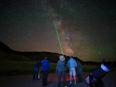 A park ranger using a laser beam identifies a constellation for park visitors attending a stargazing program in Rocky Mountain National Park, Colorado.