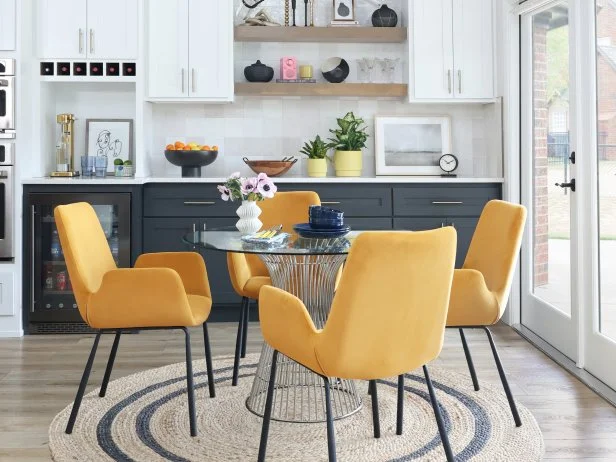 Modern Dining Nook With a Glass Table and Yellow Chairs