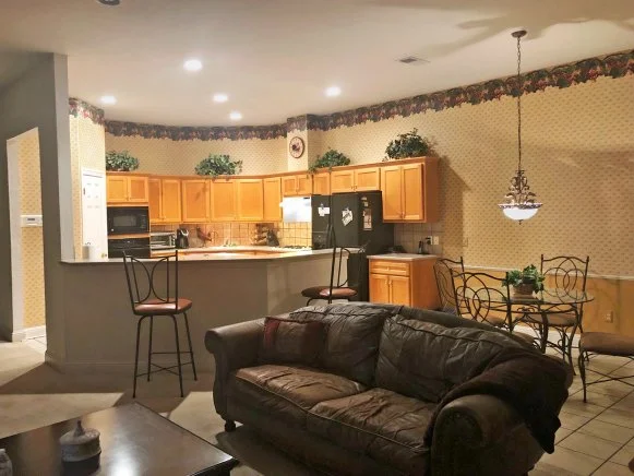 Beige Wallpapered Kitchen With Yellow-Toned Cabinets