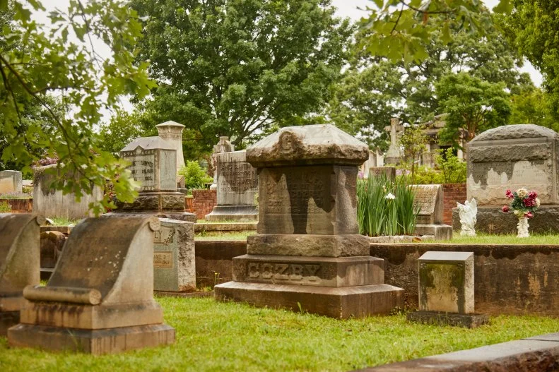 Differently-sized tombstones on a terraced plot with green grass