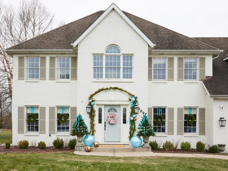 White House With Beige Shutters Decorated With Blue Holiday Decor