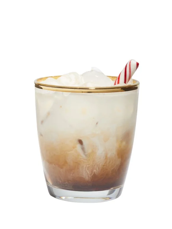 White Russian in a Gold-Rimmed Tumbler, Garnished With a Candy Cane