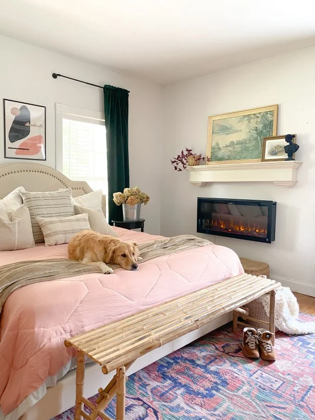 White Bedroom With Pink Bedding and an Electric Fireplace