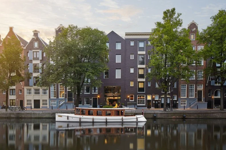 Exterior of Historic Dutch Row Houses With Boat and Canal in Front