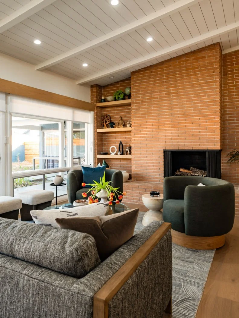 After - Drew Scott and Jonathan Scott have refurnished Bahar and Mathieu's living room with a stylish new sofa and accent chairs that will allow for easier conversation while still being able to enjoy the fireplace, as seen on Don't Hate Your House with the Property Brothers, Season 1.