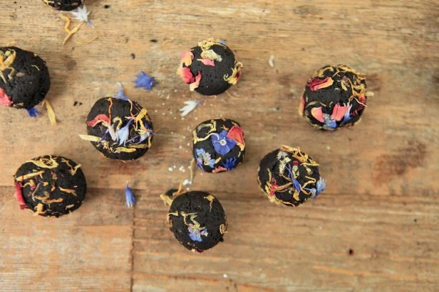 An overhead view of clay-based seed bombs after they've been rolled in dried flower petals and seeds