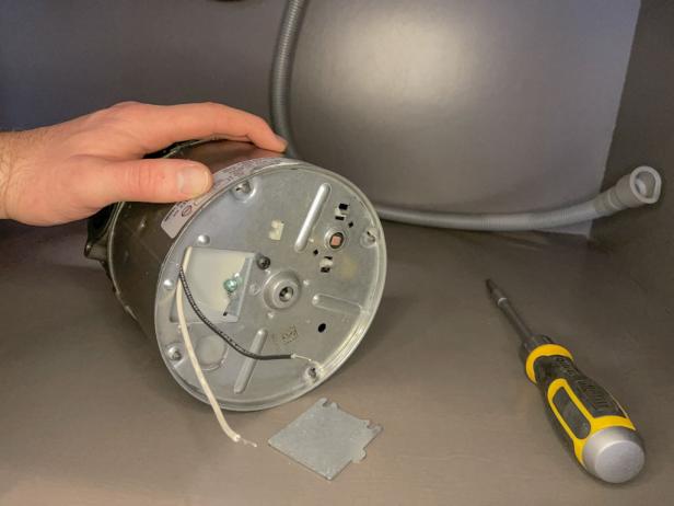 The next step in installing a garbage disposal is to pull out the wires from the cover.