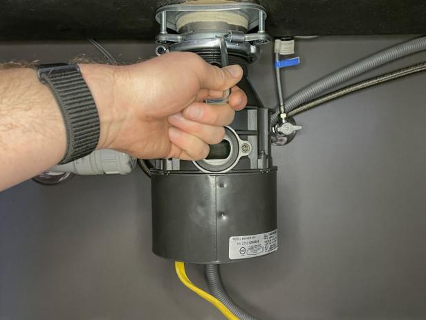 The next step in installing a garbage disposal is to lock the garbage disposal in place using the provided tool.
