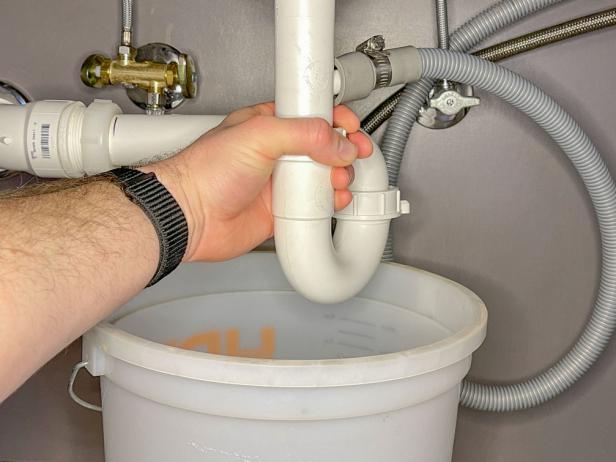 The next step in installing a garbage disposal is to unscrew the various drain connections, including the P-trap.