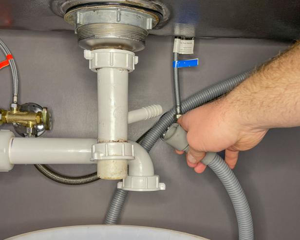 The next step in removing the plumbing to install a garbage disposal is to remove the dishwasher drain from the sink tailpiece.