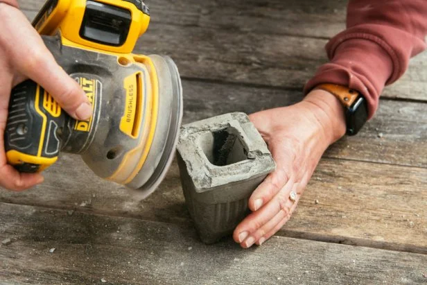 Use 80-120 grit sandpaper attached to an orbital sander to remove any imperfections