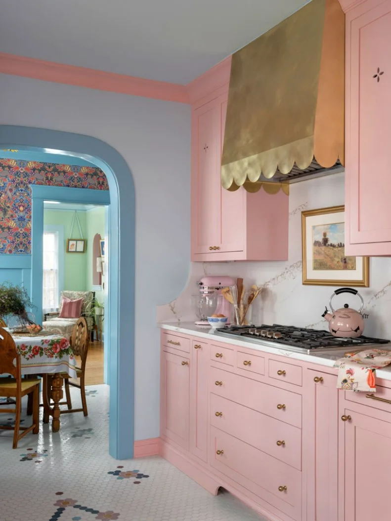 Playful Kitchen With Pink Cabinets and Brass Range Hood