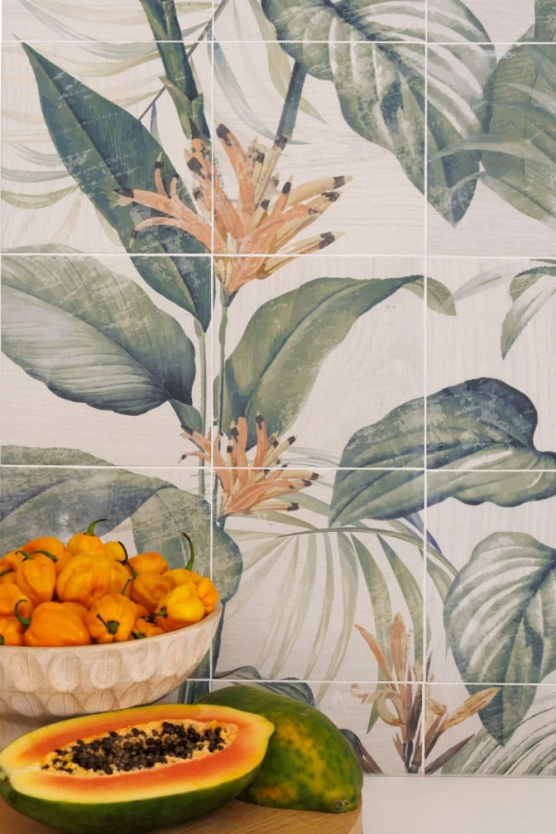 Cut-Open Papaya and Bowl of Peppers in Front of Tile Wall