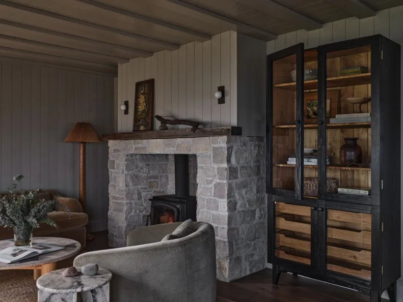 Black Cabinet Next to Large Stone Fireplace in Living Room