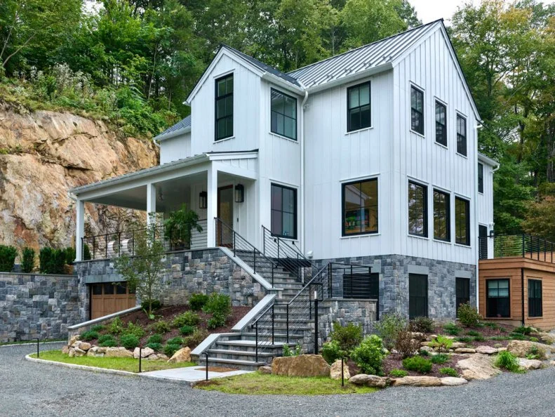 Landscaped and Hardscaped White Contemporary Home Next to Rock Shear