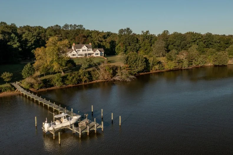 Aerial View of White Cape Cod House and Boat Dock