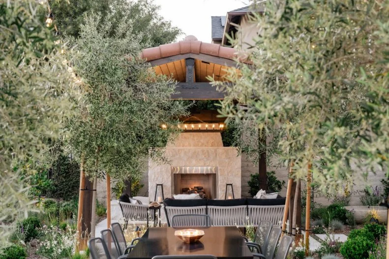 Lit Candle Atop Outdoor Dining Table Surrounded by Trees