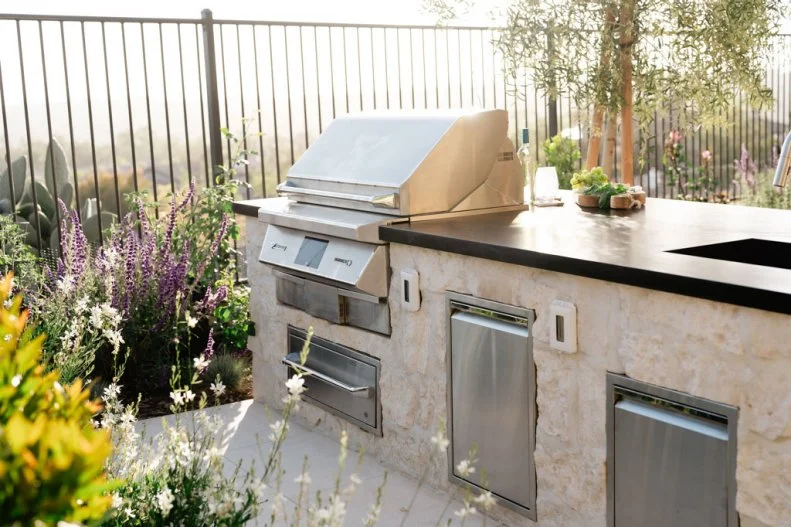 Outdoor Kitchen With Black Countertop and Built-In Grill